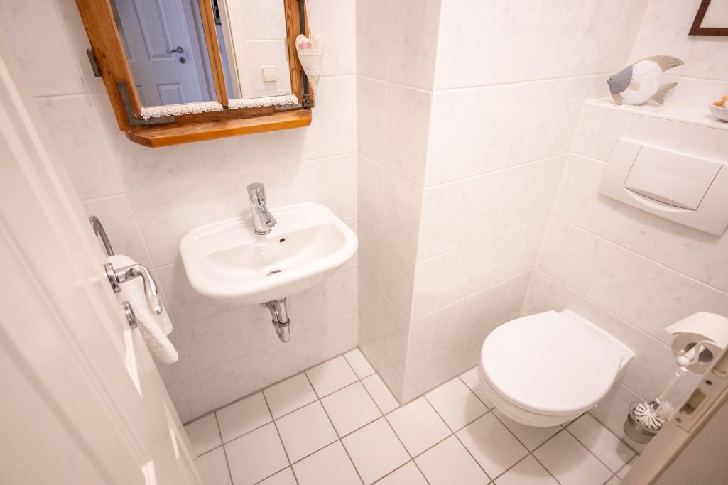 Zusätzliches Gäste-WC mit Waschbecken und Spiegel