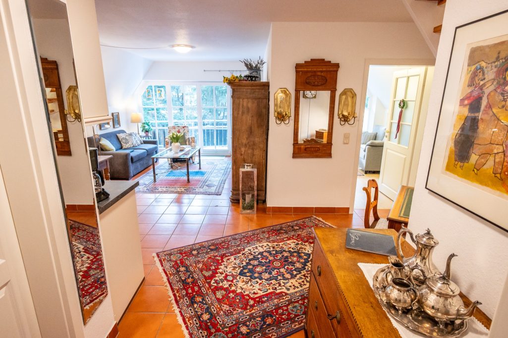 Helle Wohnung mit Teppich, Sofa, Pflanzen und Möbeln im modernen Stil.
