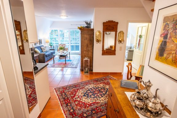 Helle Wohnung mit Teppich, Sofa, Pflanzen und Möbeln im modernen Stil.