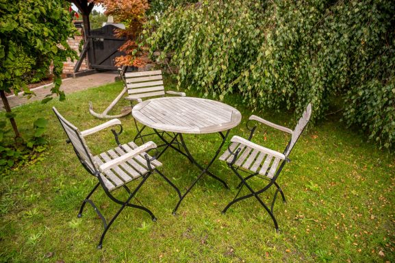 Privater Gartenbereich mit Sitzmöbeln und Holzkohlegrill